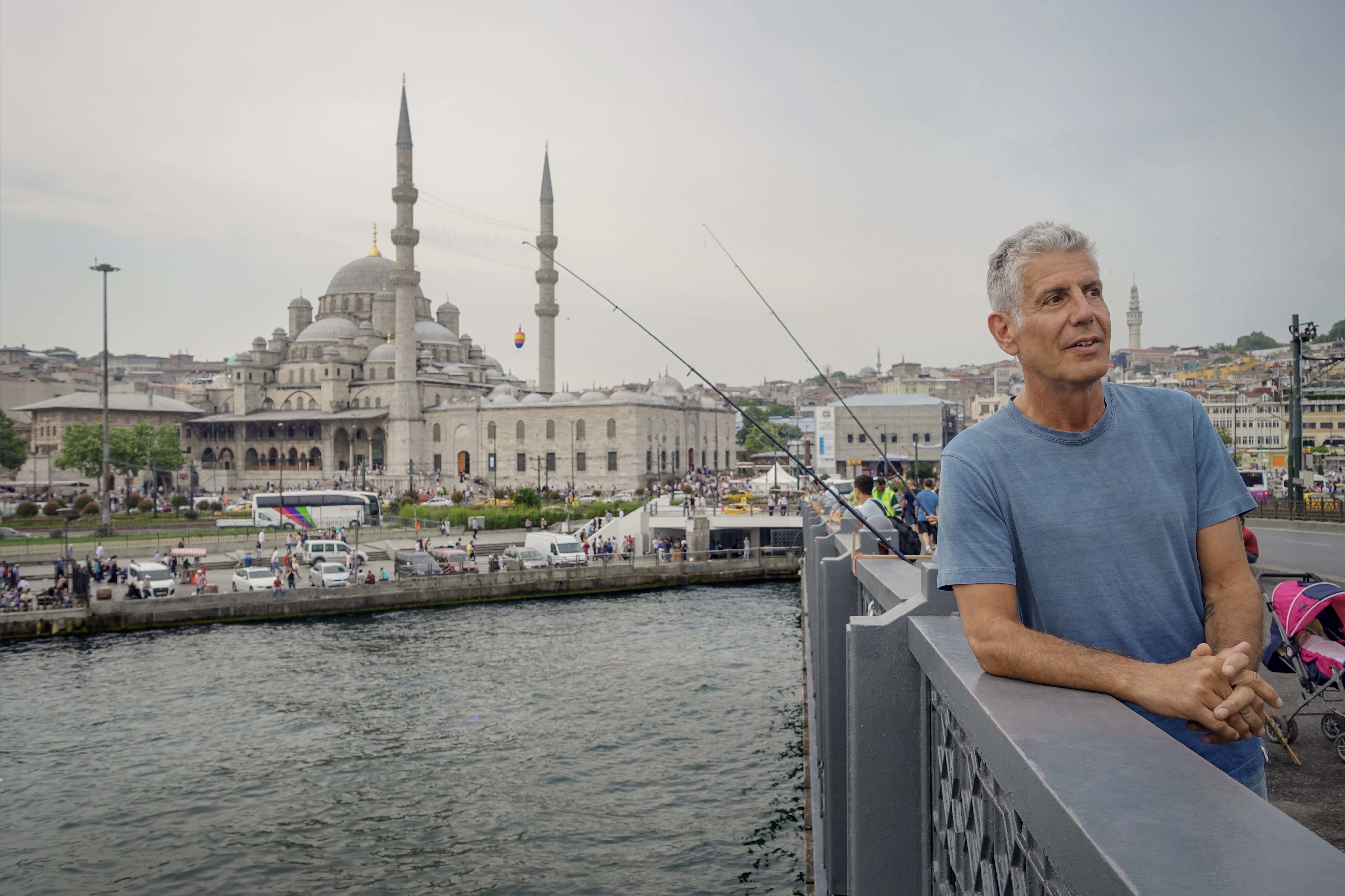 Anthony Bourdain: Parts Unknown - 315 - Istanbul Tony on the Galata Bridge in Istanbul with the Yeni Cami Mosque in the background.